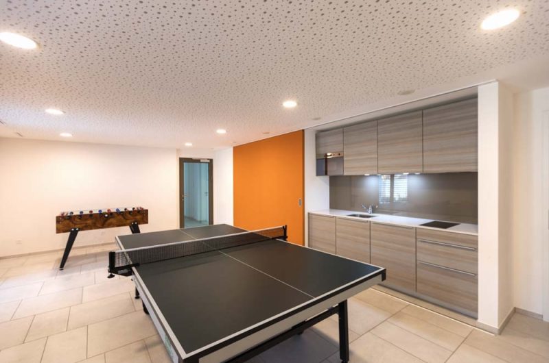 Games room with table tennis and table football. A sink countertop on one side.