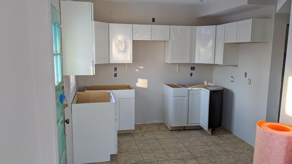 A house interior showing the living room in seamless transition to the kitchen